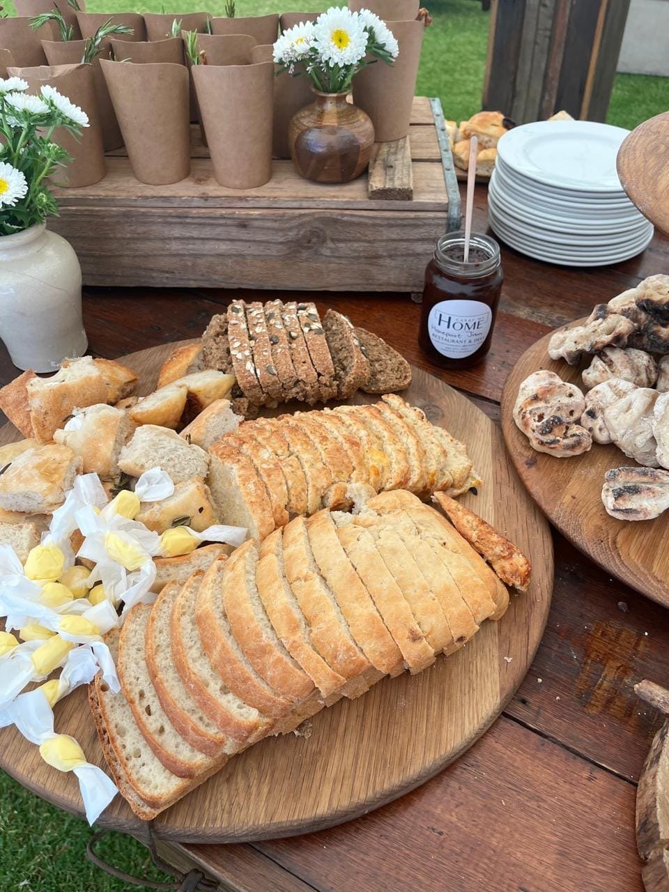 Sliced sourdough, seed loaf and flatbreads on wooden boards