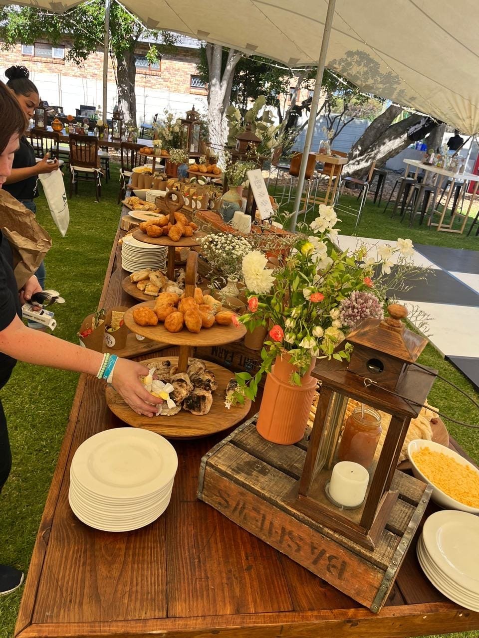 The team laying out a long grazing table under the tent