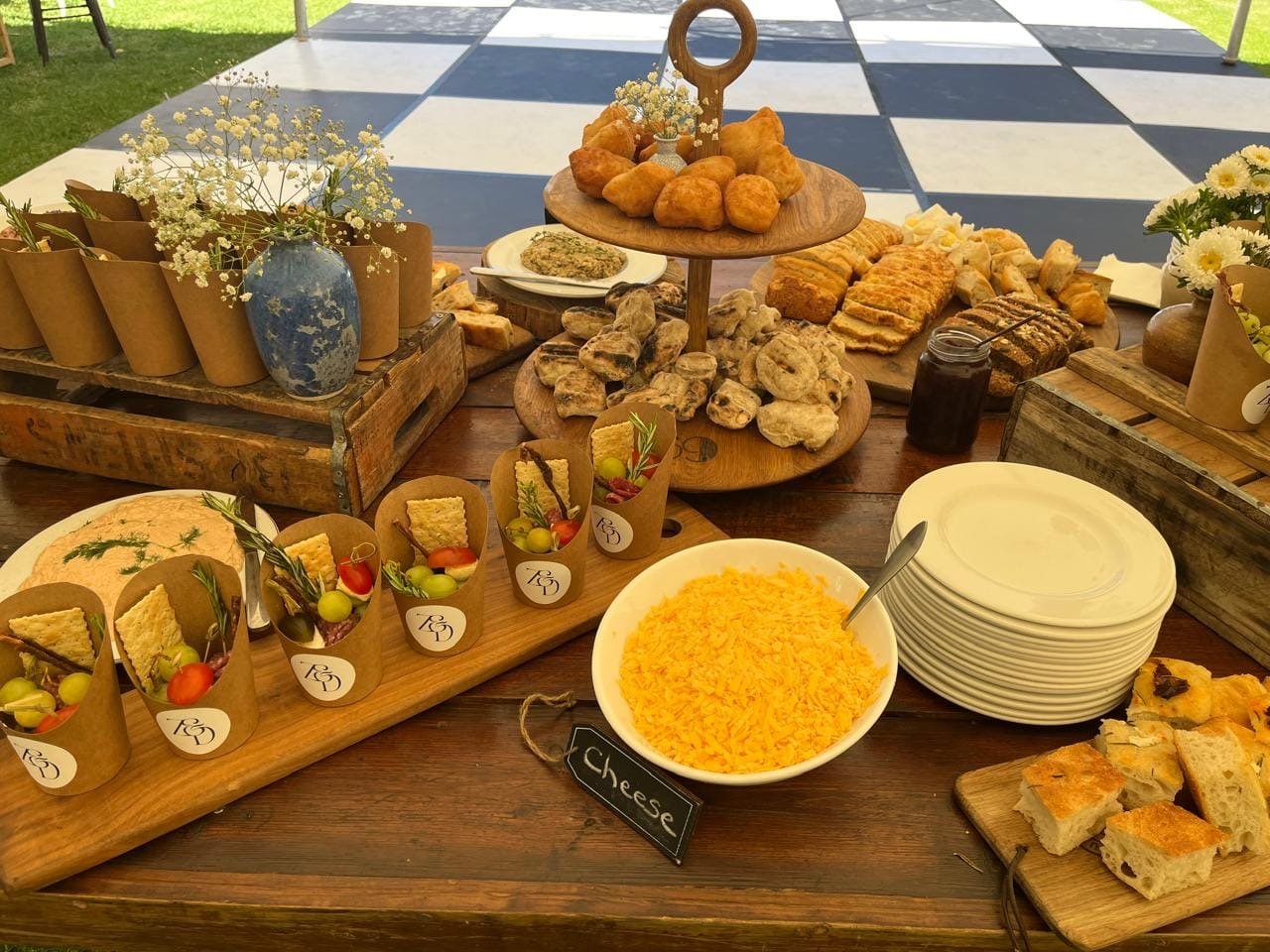 A grazing table of charcuterie cones, fresh breads, pastries and cheese