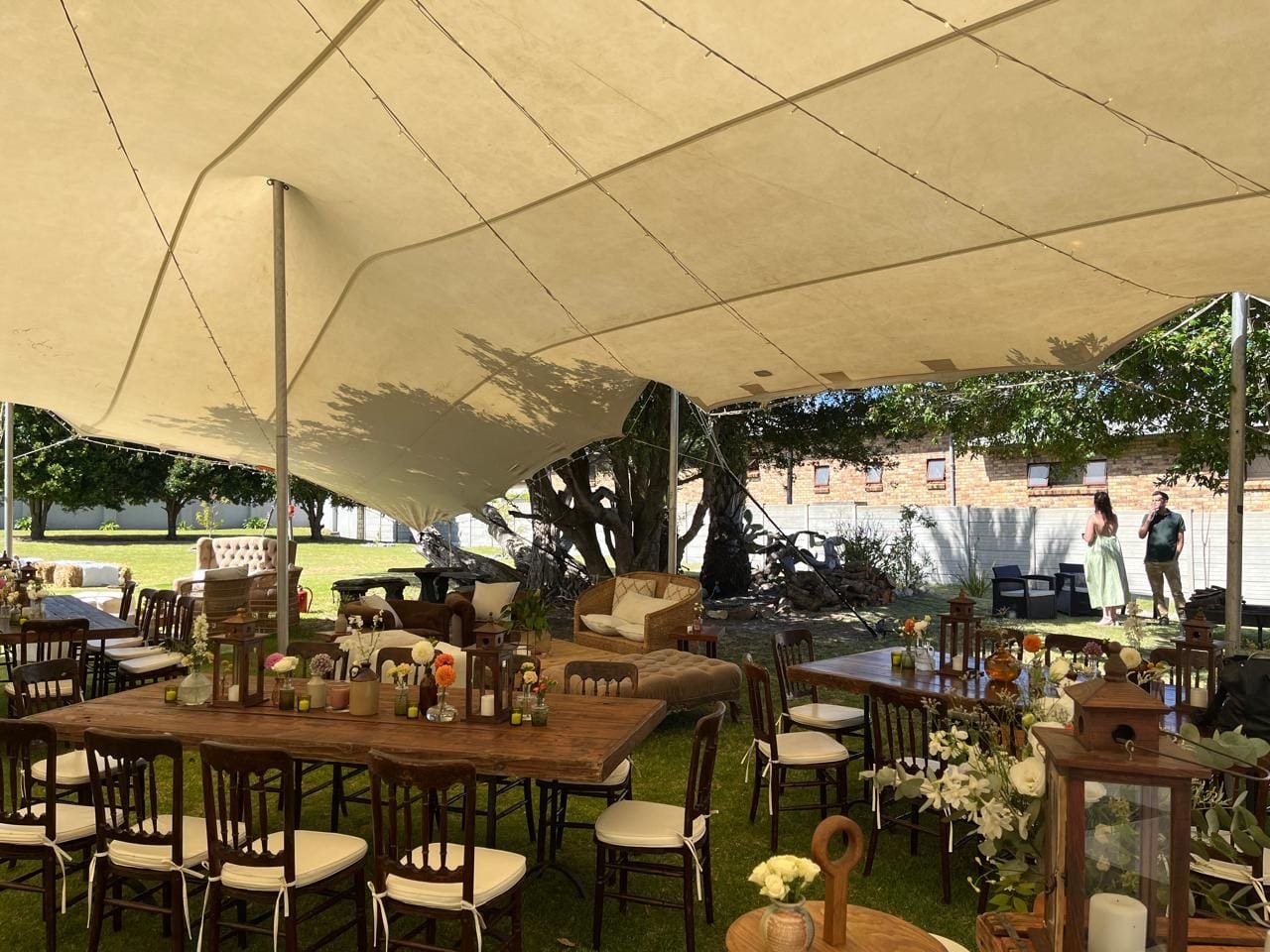 Tables set under the stretch tent in the garden at Carry Me Home