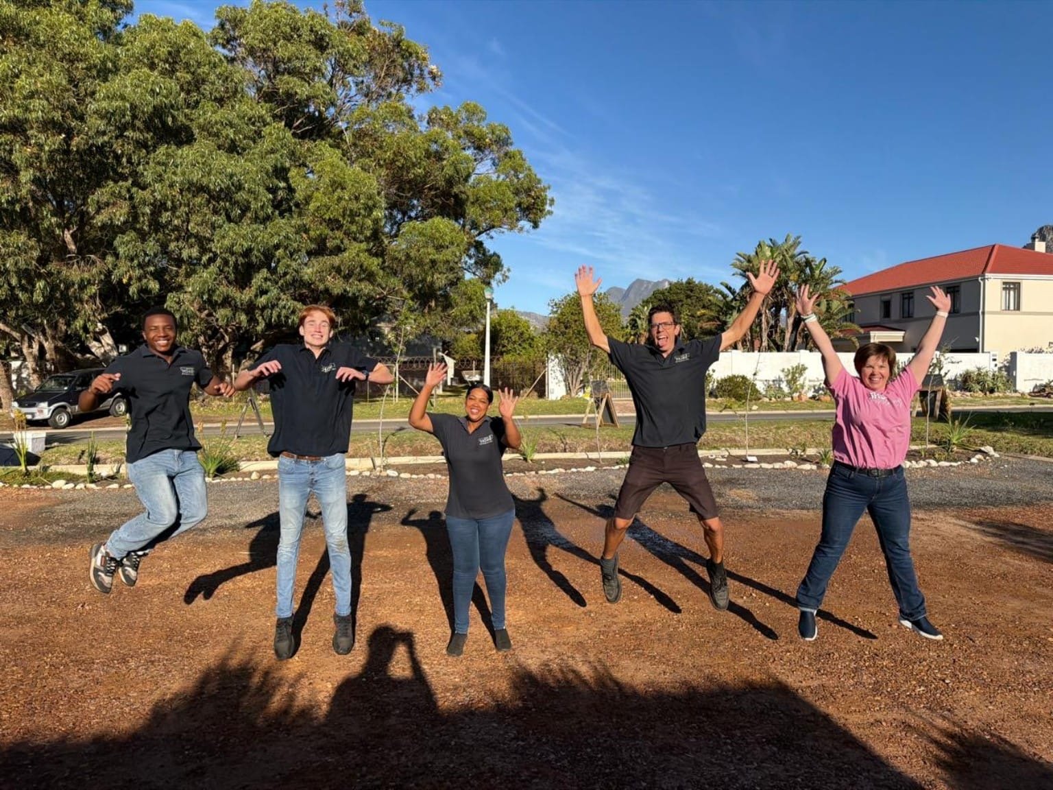 The Carry Me Home team leaping in the air outside the restaurant
